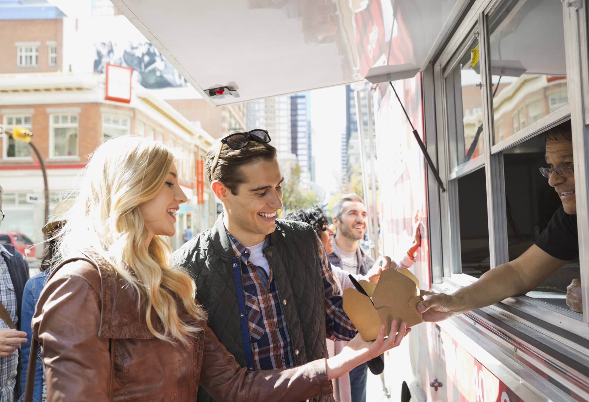 A man and a woman buying food from a food truck
