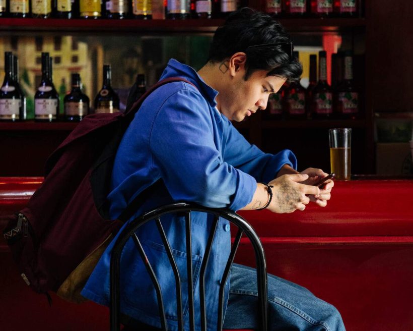 Gen z customer looking at his phone at a restaurant