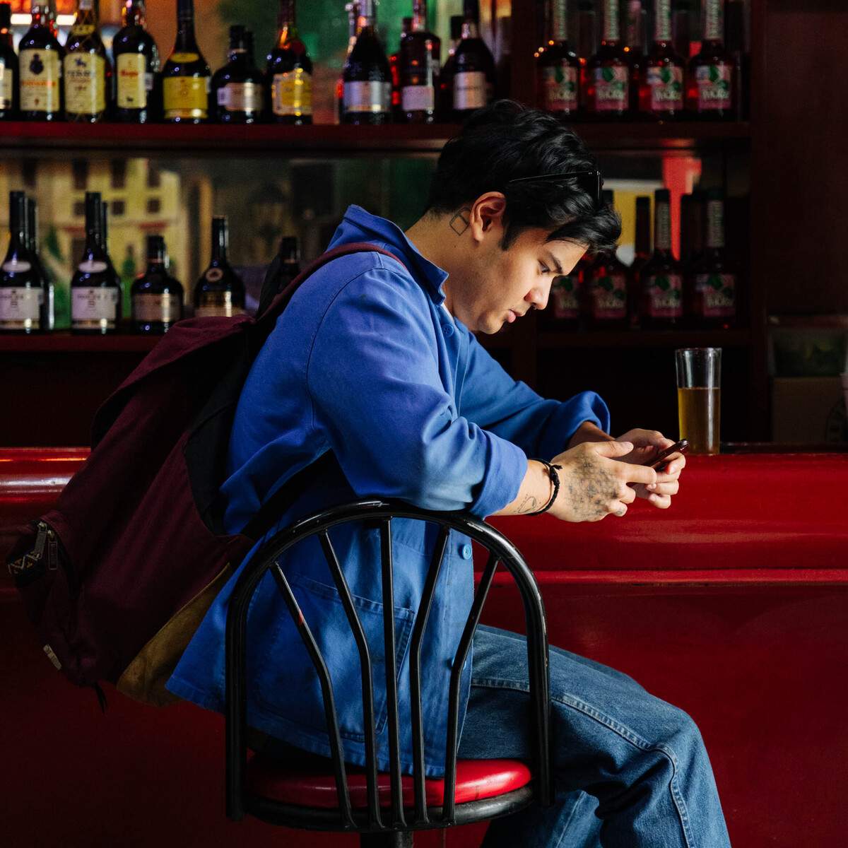 Gen z customer looking at his phone at a restaurant